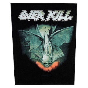 May include: Black patch featuring the band name "OVER KILL" in white, stylized lettering. The image depicts a skull with bat-like wings and a red glow. The design has a distressed, vintage aesthetic.