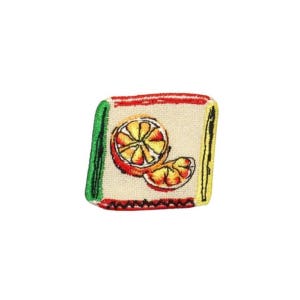 May include: A colorful embroidered patch with a white background featuring a yellow and orange orange slice. The patch has a green, red, and black border.