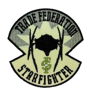 May include: A black and green embroidered patch with the text "Trade Federation Starfighter". The patch features a stylized image of a starfighter with a starburst behind it.