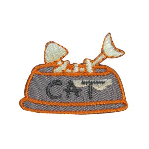May include: A gray cat food bowl with orange trim and the word "CAT" embroidered on the front. The bowl is filled with white and orange cat food.