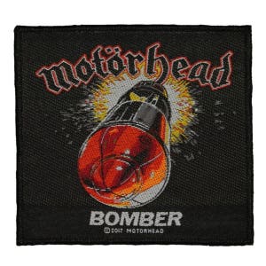 May include: Black woven patch with the band name "Motörhead" in white lettering and a red and gray rocket with flames. The text "Bomber" is below the rocket with the copyright symbol and "2017 Motörhead" in smaller white lettering.