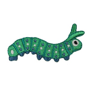 May include: Green and blue embroidered caterpillar with white spots and a single black eye.
