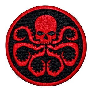 May include: Red embroidered patch with a black background featuring a skull with tentacles. The skull has eye sockets and a mouth. The tentacles are arranged in a circular pattern around the skull.