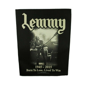 May include: Black and white image of a musician playing a bass guitar on stage. The text "Lemmy 1945 - 2015 Born To Lose, Lived To Win" is below the image.