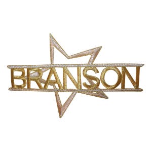 May include: Gold embroidered patch with the name "BRANSON" in a stylized font, centered within a silver outline of a five-pointed star.