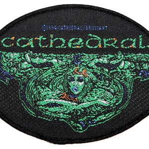 Könnte beinhalten: Ein schwarzer ovaler Patch mit einem grünen und blauen Design. Der Text "Cathedral" ist in orangefarbenen und gelben Buchstaben gedruckt.