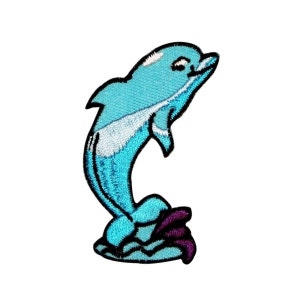 May include: An embroidered patch depicting a blue dolphin leaping from the water. The dolphin is light blue with white highlights and a purple tail fin. The dolphin is jumping out of a wave of water.