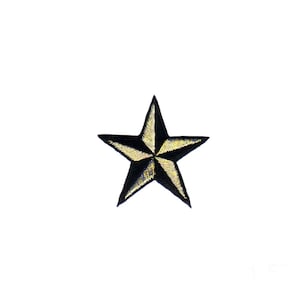 Puede incluir: Un parche en forma de estrella negro y dorado con un diseño de estrella de cinco puntas.