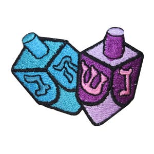 May include: Two embroidered felt dreidels, one blue and one purple, with Hebrew letters on each side.