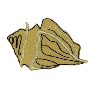 May include: Embroidered patch in the shape of a seashell. The patch features a tan background with black and off-white embroidered details outlining the shell's form. The patch is a decorative item.