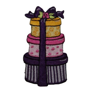 May include: A stack of three purple, pink, and yellow gift boxes with a purple ribbon and bow on top. The boxes are decorated with white polka dots and stripes.