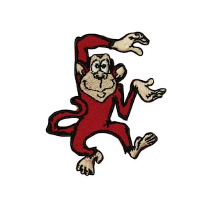 Könnte beinhalten: Gestickter Aufnäher mit einem Cartoon-Affen in einer spielerischen Pose. Der Affe ist hauptsächlich rot mit hellbraunen Händen, Füßen und Gesicht. Der Aufnäher hat ein detailliertes, gesticktes Design, ideal für Kleidung oder Accessoires.