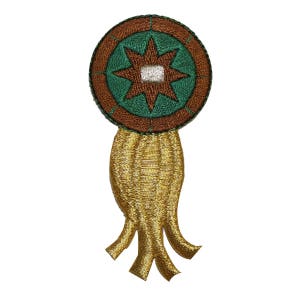 Può includere: Una toppa ricamata in oro e verde con una stella al centro e una frangia attorno ai bordi.