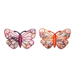 Può includere: Due toppe di farfalla ricamate, una rosa e una arancione. Entrambe le farfalle hanno uno sfondo bianco con dettagli colorati.