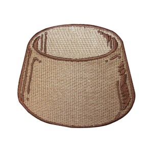 May include: A brown embroidered patch shaped like a small pot or cup. The patch has a textured surface and a slightly raised rim.
