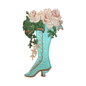Peut inclure: Une botte bleu turquoise avec un motif floral blanc et rose. La botte a une pointe pointue et un talon haut.