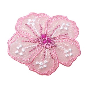 May include: Pink embroidered flower applique with a beaded center. The flower has a delicate, lacy design and is perfect for adding a touch of elegance to any project.