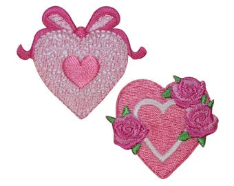 May include: Two pink embroidered heart-shaped patches. One heart has a smaller pink heart in the center and a pink bow at the top. The other heart has a white outline and is decorated with three pink roses.