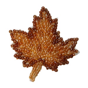 May include: A brown beaded maple leaf applique. The leaf is made of small, round beads that are sewn together to create a detailed design.