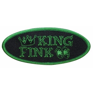 Könnte beinhalten: Grüner gestickter ovaler Patch mit dem Text "KING FINK" und einer Krone über dem Wort "KING".