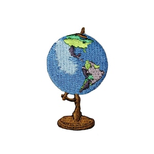 May include: A blue embroidered globe on a brown stand. The globe shows the continents of North and South America, Africa, and Europe.