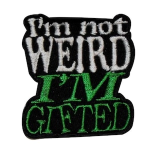 May include: Black embroidered patch with white and green lettering. The text reads "I'm not weird I'm gifted".
