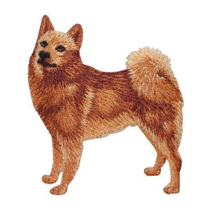 May include: Embroidered patch of a Finnish Spitz dog, a small breed with a fox-like appearance. The dog is brown and white with a fluffy tail and a pointed muzzle.