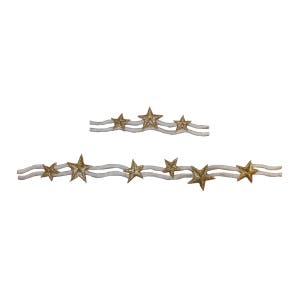 May include: Two rows of gold glitter stars on a white ribbon. The stars are arranged in a wavy pattern.