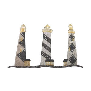 May include: Three black and white striped lighthouses with gold accents and a small house at the base of each. The lighthouses are embroidered on a white background.