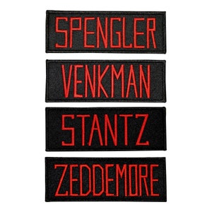 May include: Four black fabric patches with red embroidered text. The patches read "Spengler", "Venkman", "Stantz", and "Zeddemore".