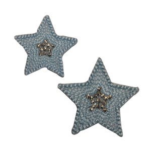 May include: Two light blue fabric star-shaped patches with a gold and silver star design in the center.