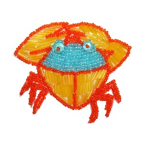 May include: A beaded crab applique with a blue body, orange legs, and yellow shell. The crab is made of small, colorful beads and is perfect for adding a touch of whimsy to any project.