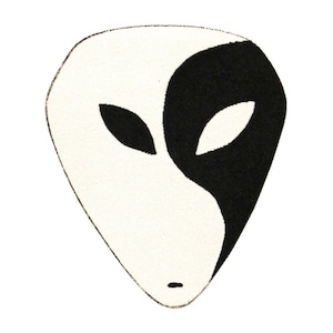 May include: A white and black alien face patch with a yin yang design. The alien has two eyes and a small mouth.