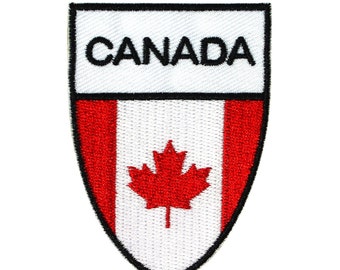 May include: A red, white, and black embroidered patch with the word "CANADA" in black lettering and a red maple leaf on a white background.