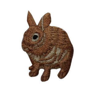 May include: A brown embroidered rabbit patch with white accents. The rabbit is sitting on its hind legs with its front paws in front of it.