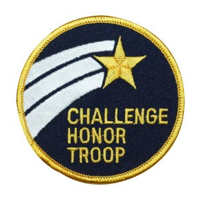 May include: A round, navy blue patch with a gold border and white stripes. A gold star is in the top right corner. The text "Challenge Honor Troop" is in gold letters.