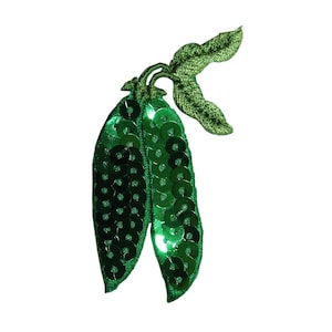 May include: Green sequin pea pod with a green stem and leaves. The pea pod is made of fabric and sequins.