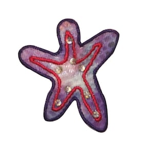 May include: A purple and white fabric starfish with red stitching and silver sequins.