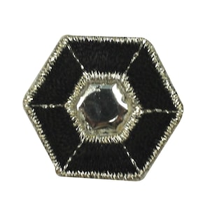 May include: A black hexagonal patch with a silver, diamond-shaped embellishment in the centre. The patch has a silver border and is stitched with black thread.