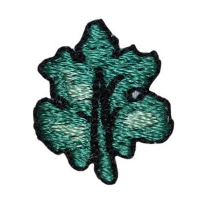 May include: A green embroidered leaf patch with a black outline.