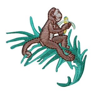 May include: Embroidered iron-on patch of a brown monkey sitting on a green palm leaf, eating a yellow banana.