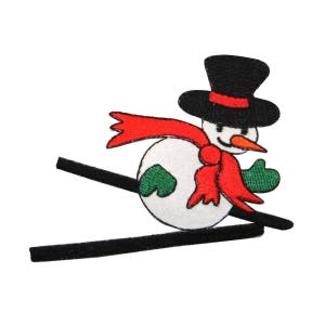 May include: A white snowman wearing a black top hat and a red scarf is skiing down a black ski slope. The snowman has green arms and a black carrot nose.