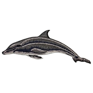 May include: A black and silver embroidered patch of a dolphin leaping out of the water.