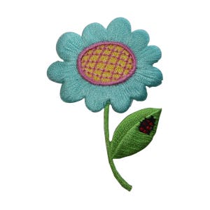 Può includere: Un fiore ricamato blu con un centro giallo e rosa e uno stelo verde con una coccinella rossa su una foglia.