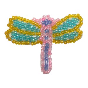 May include: A beaded dragonfly applique with yellow, blue, and pink beads. The dragonfly has a long, thin body and two pairs of wings.