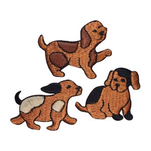 May include: Three embroidered iron-on patches of brown dogs. The dogs are in different poses, one is sitting, one is standing, and one is walking.