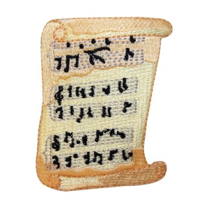 May include: A beige embroidered patch shaped like a rolled up scroll with black musical notes and symbols on it.