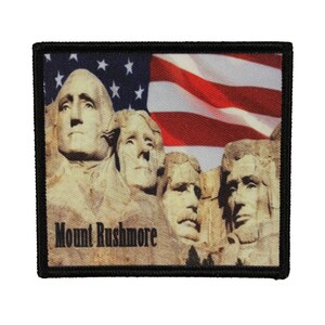 May include: A black and white patch featuring a photo of Mount Rushmore and the American flag. The text "Mount Rushmore" is printed below the image.