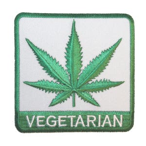 Può includere: Toppa ricamata verde con un disegno a foglia di marijuana e la parola "VEGETARIANO" in testo bianco.