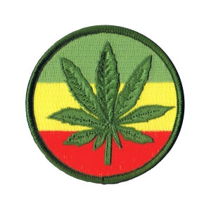 May include: A green marijuana leaf embroidered on a circular patch with red, yellow, and green stripes.